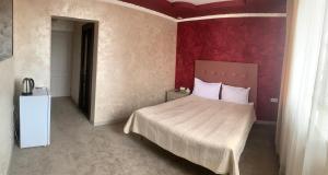 1 dormitorio con cama y pared roja en Hotel MARUNA, en Sevan