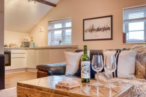 a living room with a couch and wine glasses on a table at The Station Loft City Centre 1-Bed Apartment in Worcester