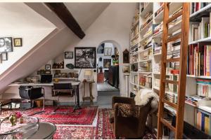 um quarto no sótão com uma biblioteca com estantes de livros em A writer's flat em Paris