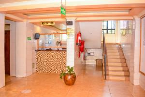 um corredor com uma escada num edifício em Omega Gardens Hotel em Karatina