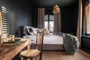 sypialnia z łóżkiem, stołem i krzesłami w obiekcie The Bank 1869 - Unique guestrooms in the historic center of Bruges w Brugii