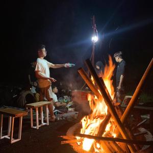 a group of people standing around a fire at Volcano rim Glamping Kintamani in Kubupenlokan