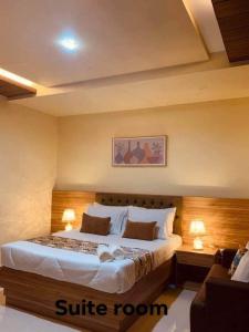 a bedroom with a large bed with two lamps at Golden Suites in General Santos
