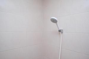y baño con ducha con cabezal de ducha. en KoolKost Syariah near Luwes Gentan Park (Minimum Stay 30 Nights), en Sukoharjo