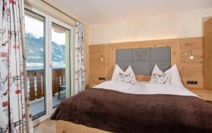 una camera da letto con un letto grande e una grande finestra di Seehotel St Hubertus a Pertisau
