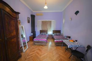 a room with four beds in a room with wooden floors at Leon Rooms in Tbilisi City