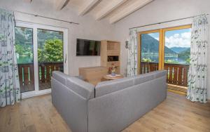 a living room with a couch and a large window at Seehotel St Hubertus in Pertisau