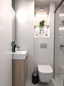a white bathroom with a sink and a toilet at WEFLATING Fira in Hospitalet de Llobregat