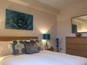 a bedroom with a white bed and a mirror at AB11 Apartments - Portland Street in Aberdeen