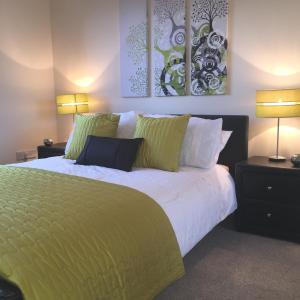 a bedroom with a large bed with green sheets and pillows at AB11 Apartments - Portland Street in Aberdeen