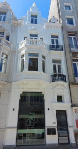 オーステンデにあるCamelias@sea - Appartementの窓とバルコニー付きの白い大きな建物
