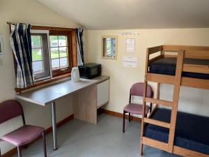 een kamer met een bureau en een stapelbed bij Trekker Hut in Tyndrum