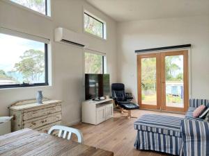 a living room with a couch and a table at The Beach Box at Big Roaring Beach Tasmania in Surveyors Bay