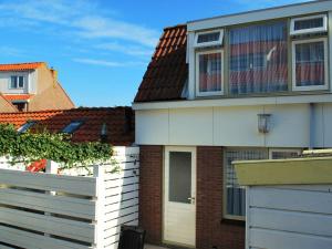 una casa con una cerca blanca delante de ella en Vakantiehuis Seahorse en Egmond aan Zee