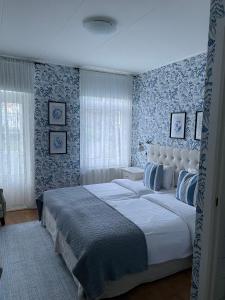 um quarto com uma cama grande e papel de parede azul e branco em Nautic Hotell em Marstrand