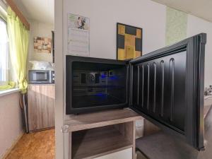 a flat screen tv sitting on a stand in a kitchen at Landhaus "Kühler Morgen", Appartement mit 140er Futonbett, Teeküche, Bad 