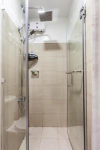 a shower with a glass door in a bathroom at Shore 2 Apartment with Balcony in Manila