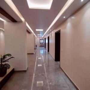 a hallway with white walls and a ceiling at Hotel Luxuria in Ludhiana