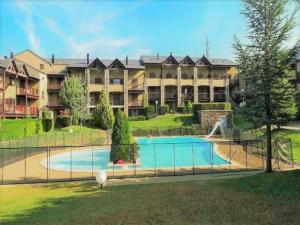 duży kompleks apartamentów z basenem przed budynkiem w obiekcie Preciosa casa con jardín y piscina w mieście Bourg-Madame