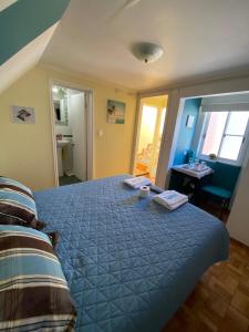 Schlafzimmer mit einem Bett mit blauer Decke in der Unterkunft Anyrcoy in Viña del Mar