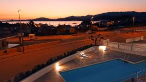 uma piscina no topo de um edifício com um pôr-do-sol em Welcomely - White Terrace - Condominio AcquaLife em Cannigione