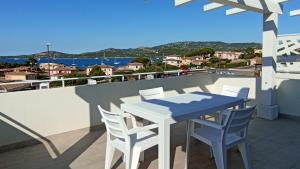 uma mesa e cadeiras numa varanda com vista para o oceano em Welcomely - White Terrace - Condominio AcquaLife em Cannigione