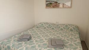 a bed with two towels on top of it at Welcomely - White Terrace - Condominio AcquaLife in Cannigione