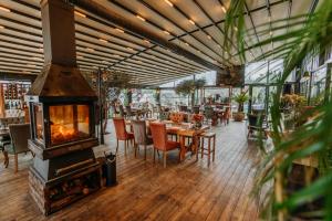 a restaurant with a fireplace and tables and chairs at Doors Urla Hotel & Bungalows in Izmir