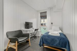 1 dormitorio con cama, silla y escritorio en Norpark Romutleie, en Orkanger