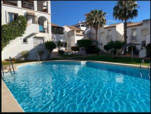 a large blue swimming pool in front of a building at Playa Flamenca 151 in Playa Flamenca