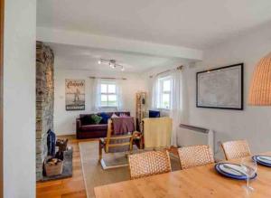 sala de estar con mesa y sofá en Pink Cottage, en Ballyconneely