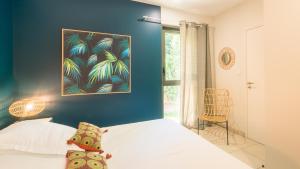 Un dormitorio con una cama blanca y una pared azul. en La chambre Sweety, en Sarlat-la-Canéda