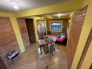 uma vista aérea de uma sala de estar com uma mesa e um sofá em Casa Girassol em Conceição do Ibitipoca