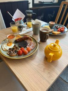 a table with a breakfast of eggs and bacon at Old Manor House in Axbridge