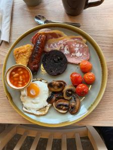 un piatto di prodotti per la colazione con uova, salsicce e funghi di Old Manor House ad Axbridge
