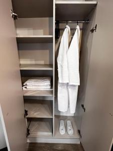 a closet with white towels and shoes in it at Chikhi in Tbilisi City