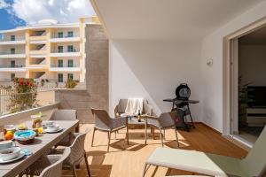 een woonkamer met een balkon met een tafel en stoelen bij Marina Pearl Deluxe Lagos Apartment by Ideal Homes in Lagos