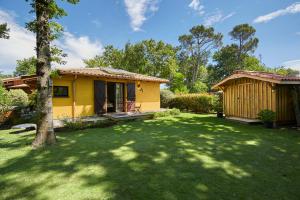 a small yellow house in a yard with a tree at Salamandre et Hippocampe in Lanton