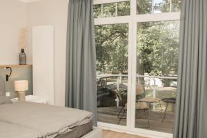 a bedroom with a bed and a sliding glass door at sea and salt in Timmendorfer Strand