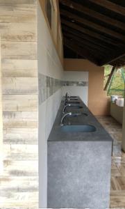 a kitchen with a counter with a row of sinks at Camping des Cigales in Aiguèze