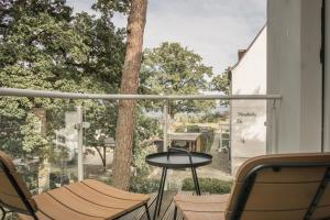 a balcony with a table and chairs and a window at sea and salt in Timmendorfer Strand