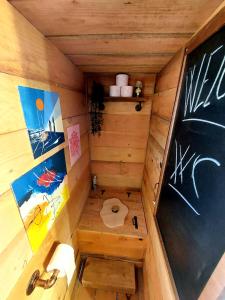 a small bathroom with a toilet and a chalkboard at Cabane insolite TOUT CONFORT Chalet Gites Luzy Morvan Bourgogne in Luzy