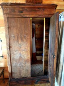 a wooden door in a room with a mirror at Cabane insolite TOUT CONFORT Chalet Gites Luzy Morvan Bourgogne in Luzy