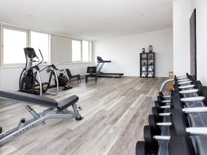 um ginásio com passadeiras e máquinas de exercício numa sala em DORMERO Hotel Hannover-Langenhagen Airport em Hanôver