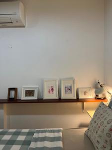 a shelf with framed pictures on it next to a bed at Island House Rentals 48 in Ko Samed