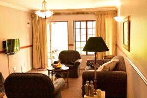 沙比耶的住宿－River Suites Sabie，客厅配有沙发、椅子和台灯