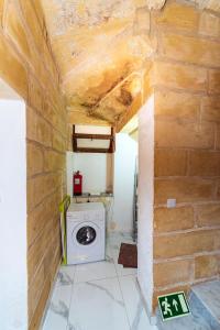 a washer and dryer in a room with a brick wall at Valletta Old Well Apartments in Valletta