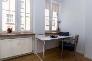 uma secretária branca num quarto com duas janelas em Hello Apartments Modena Sw Ducha em Gdansk