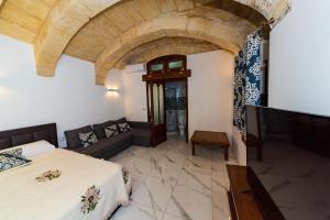 a bedroom with a bed and a couch in a room at Valletta Old Well Apartments in Valletta
