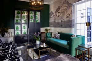 a living room with a green couch at Cape Cadogan Boutique Hotel in Cape Town